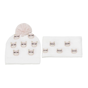 Close-up of white knit hat and scarf set featuring cute cat face embroidery and pink pom-poms