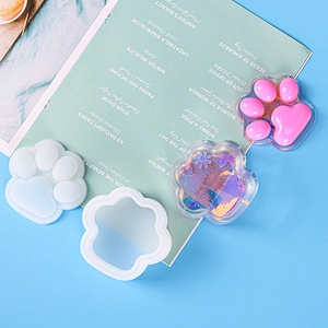Cat paw storage box silicone mold with DIY resin crafts on a colorful background