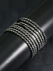 Macro shot of a seven-piece set of silver rope chain bracelets with twisted metal textures