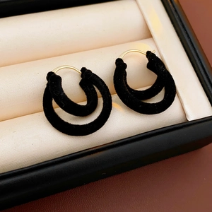 Gros plan de boucles d'oreilles vintage en velours noir et finition en métal doré