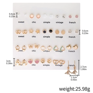 Detail view of 20 pairs earring set with gold hearts pearls and crystals on white display