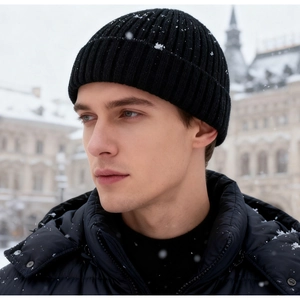 Close-up of black ribbed knit beanie with snow details worn by a model in winter