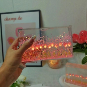 Detail of DIY tulip night light with flowing pink petals and glowing LED in acrylic box