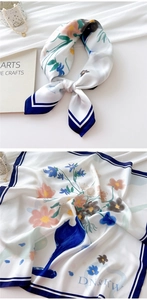 Detailed view of floral silk scarf with navy blue borders and elegant hand-painted patterns