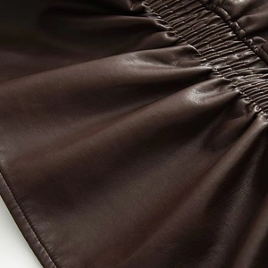 Détail du simili cuir marron foncé vintage avec coutures plissées et texture
