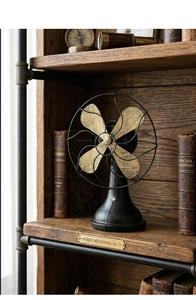 Macro view of vintage industrial decorative fan with aged gold blades on a rustic bookshelf