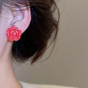 Close-up of red rose flower earrings on model showing realistic petal texture and size