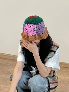 Close-up of handmade crochet bucket hat with colorful patchwork and floral wavy edges