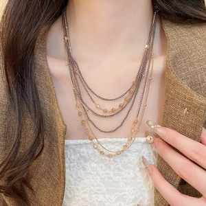 Detail view of multi-layered bronze necklace with champagne crystal beads on model
