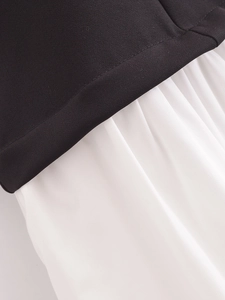 Close-up of black and white fabric contrast on a strapless midi dress with textured seams