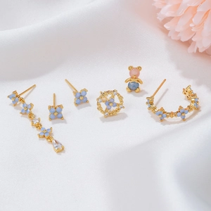 Elegant flower tassel earring set with blue zircon accents on a white silk background