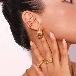 Detail view of 18K gold teardrop earrings with multi-color stones and textured rings