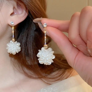 Eleganti orecchini a fiore con petali bianchi, nappe a catena d'oro e strass luccicanti