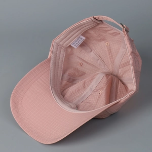 Detail of pink plaid baseball cap inner lining with sweatband and metal buckle
