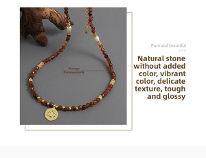 Detailed macro view of orange garnet beads and a golden evil eye coin pendant on necklace