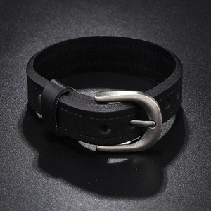 Detail of black leather punk wristband with vintage silver metal buckle and stitching