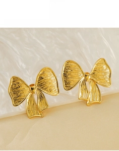 Vue détaillée de boucles d'oreilles nœud en acier titane plaqué or 18K avec rainures