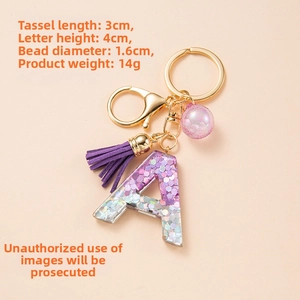 Detailed view of purple resin letter A keychain with tassel and dimensions labels