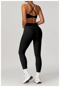 Dettaglio dei leggings neri a vita alta e del set reggiseno sportivo con incrocio dietro