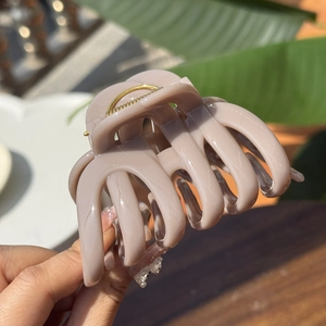 Close-up of a large beige milk tea claw clip with durable gold metal spring for thick hair