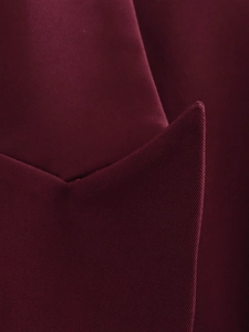 Dettaglio delle cuciture fini e della texture del tessuto sul bavero di un blazer bordeaux