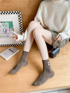 Close-up of brown cotton mid-calf socks with white heart embroidery in autumn style