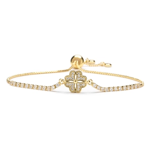 Detail van verstelbare gouden armband met klaverbedeltje bezet met fonkelende zirkonia-stenen
