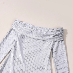Détail d'une robe argentée à paillettes montrant l'encolure plissée et la texture du tissu