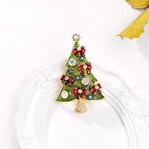 Close-up of green enamel Christmas tree brooch with colorful rhinestones and gold star