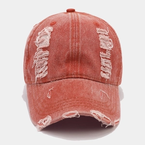 Vue détaillée d'une casquette baseball en denim délavé avec trous usés et bords effilochés