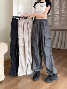 Detail of cargo pants with adjustable drawstrings at waist and hem plus large side pockets