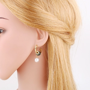 Detail of gold hoop earring with green pavé crystals and elegant white pearl pendant