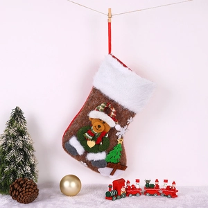 Détail d'une chaussette de Noël en peluche avec ours et sapin suspendue au sapin festif
