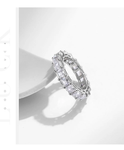 Macro shot of silver S925 ring featuring emerald-cut cubic zirconia in a full eternity band
