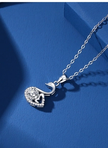Macro shot of silver swan necklace pendant with large round diamond and micro-pave detailing