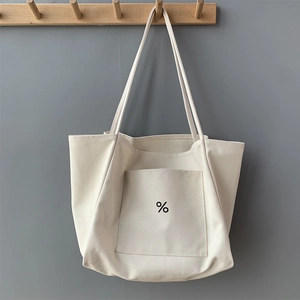 Close-up of minimalist cream canvas tote bag showing thick texture and percent symbol