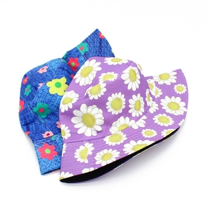 Detailed close-up of double-sided bucket hats with purple daisy and colorful floral patterns
