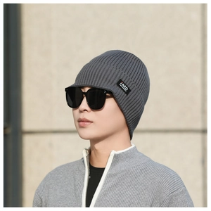 Close-up of a dark grey ribbed knit beanie with a black FARD logo label detail