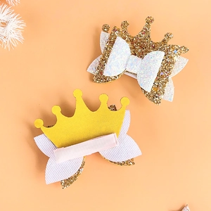 Golden glitter and yellow fabric crown hair clips for girls on a pink background