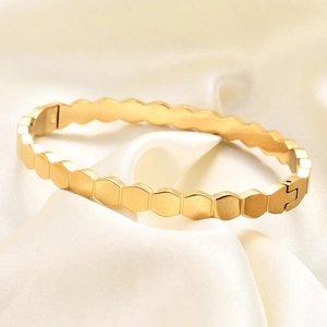 Minimalist 60mm golden hexagonal honeycomb bangle with brushed finish and side clasp