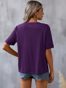 Detail view of purple short-sleeve embroidered top showing the back fit on a model