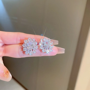 Gros plan sur des boucles d'oreilles fleur en zircon avec finition argentée