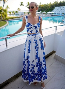 Women's floral crop top and high-waisted maxi skirt set shown on a tropical balcony