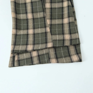 Pantalon à carreaux vert et kaki montrant la texture du tissu et l'ourlet précis