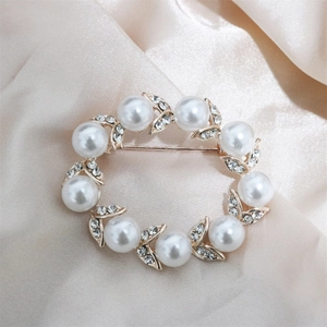 Elegant pearl and rhinestone wreath brooch with golden alloy base on champagne silk