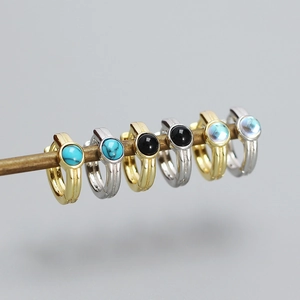 Detailed row of gold and silver hoop earrings with turquoise and black gemstones