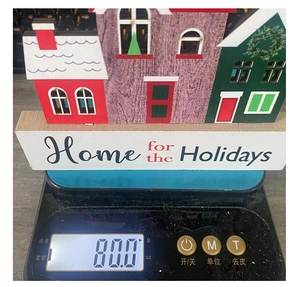 Detailed view of wooden Christmas house decor on a digital scale showing 80.0g weight