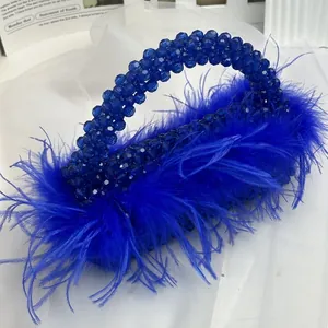 Detail of royal blue beaded evening handbag with elegant ostrich feather trim and texture