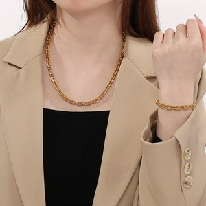 7mm gold stainless steel curb chain necklace and bracelet set worn by a model