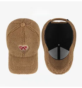 Detail of brown lamb wool baseball cap with heart bow embroidery and interior lining